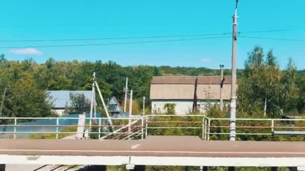 Ett landskap av en by-skytte från tåget-kommer närmare tågstationen — Stockvideo