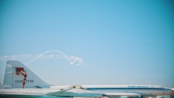 29 AGOSTO 2019 MOSCA, RUSSIA: aerei reattivi che volano nel cielo e che eseguono lo spettacolo lasciando linee di fumo - persone che dipingono una parte di un aereo in primo piano — Video Stock