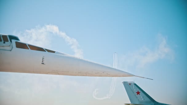 Reactive planes flying in the sky and performing the show - flying apart - A sharp front part of an airplane on the foreground — Stock Video