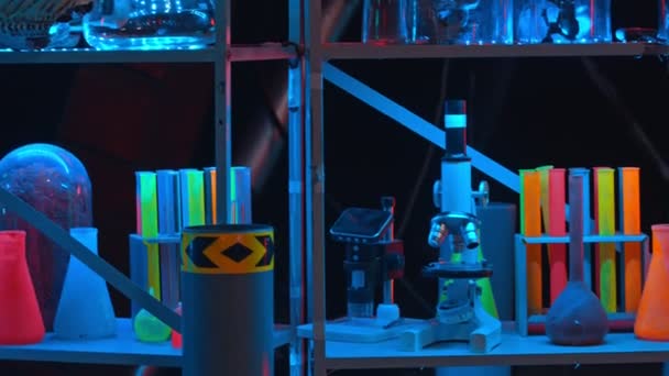 Hylla med flerfärgade kolvar och apparater i laboratoriet — Stockvideo