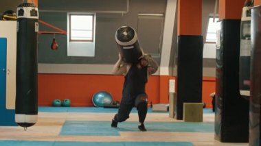 Omzunda kum torbası taşıyan bir adam vücut geliştirmeci