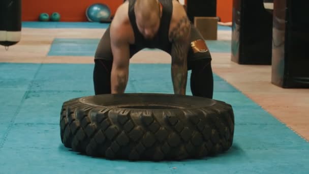 Un bodybuilder homme renverse un gros pneu — Video