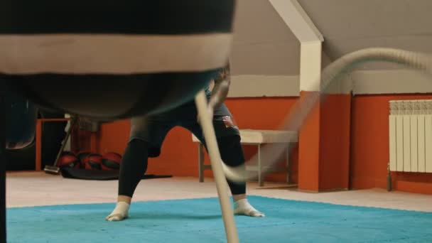 Мускулистый человек тренируется с веревками — стоковое видео
