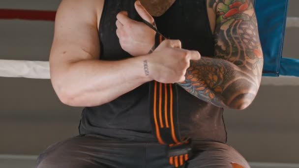 Ein muskulöser Mann mit elastischem Verband, der sein Handgelenk bedeckt — Stockvideo