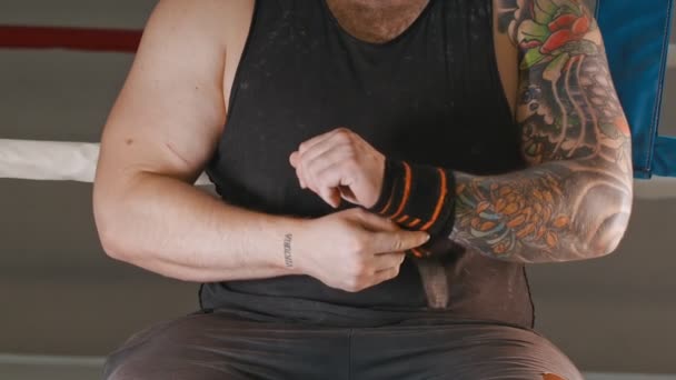 A muscular man applying elastic bandage on his wrist — Stock Video