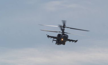 Işıklar açık gökyüzünde uçan iki çift bıçakları ile bir askeri savaş helikopteri