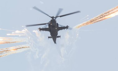 Askeri bir savaş helikopteri sis bombaları kullanarak bir sis perdesi yayılır