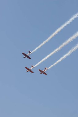 Gökyüzünde uçan ve duman izleri bırakarak bir gösteri gerçekleştiren üç renkli jetler