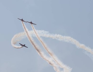 Gökyüzünde uçan ve duman işaretleri bir gösteri performans üç renkli jetler - iki jetleri uçan ve üçüncü bir etrafında sinek