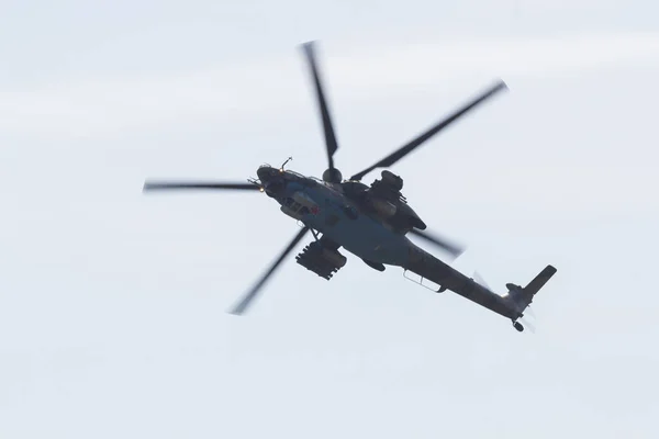 Ein Militärhubschrauber mit roten Sternen auf der unteren Bildfläche, der in den weißen Himmel fliegt — Stockfoto