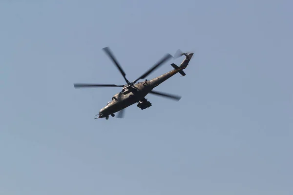 Un helicóptero militar verde con cuchillas delgadas volando en el cielo — Foto de Stock