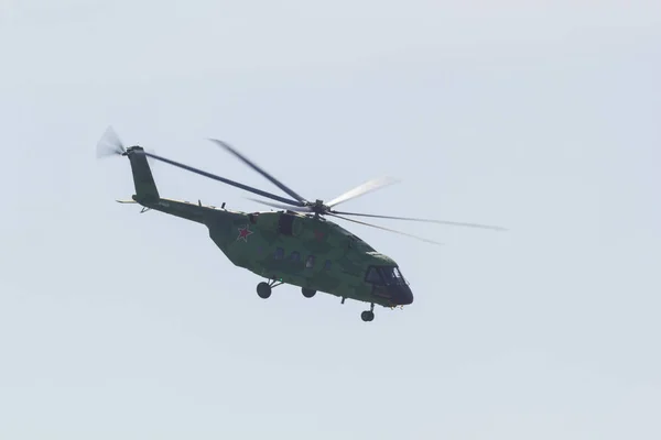 Um helicóptero militar verde com estrela vermelha na carcaça voando no céu — Fotografia de Stock