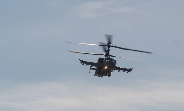 Ein militärischer Kampfhubschrauber mit zwei Rotorblättern am Himmel mit eingeschaltetem Licht — Stockfoto