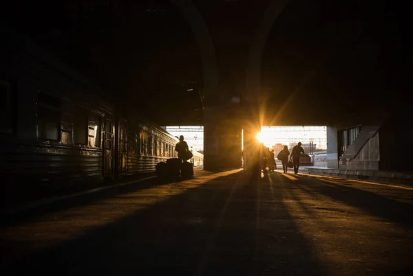 Silhuettes of people walking to the train - sunset — Stock Photo, Image