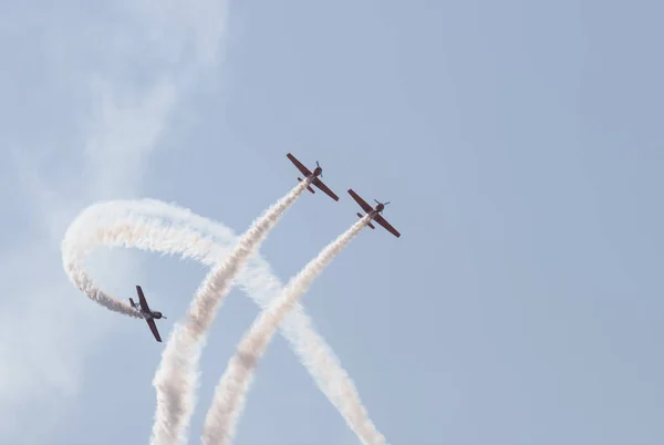 Three jets flying in the sky and performing a show of the smoke marks - two jets flying up and the third one fly around them — Stock Photo, Image