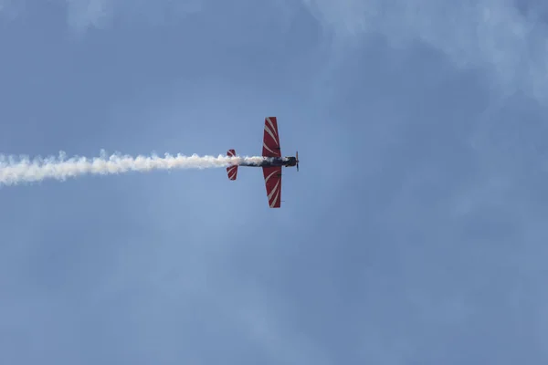 青空を飛ぶ赤い軍用ジェット機と煙跡を残すショーを行う — ストック写真