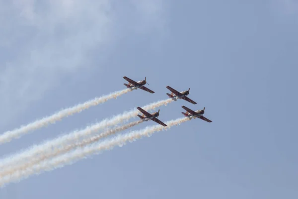 Vier militaire jets vliegen in de blauwe lucht en het uitvoeren van een show verlaten rook merken — Stockfoto