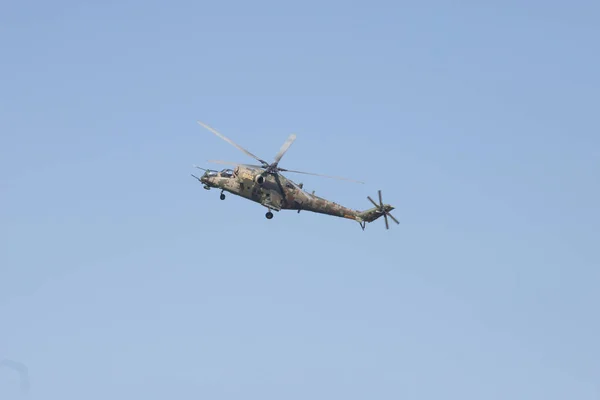 Um helicóptero militar verde voando céu azul claro — Fotografia de Stock