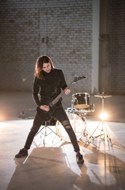 Gitar çalan bir müzisyen adam - arka planda bir davul-kiti