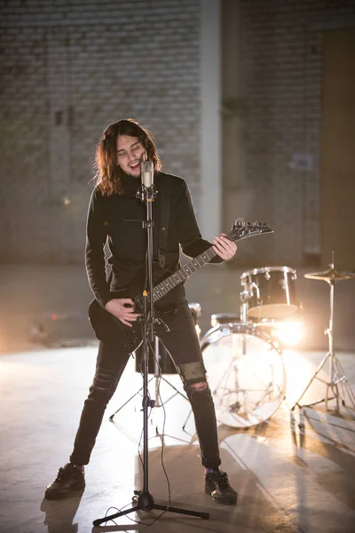 A musician man playing guitar and singing in the mic — Stock Photo, Image