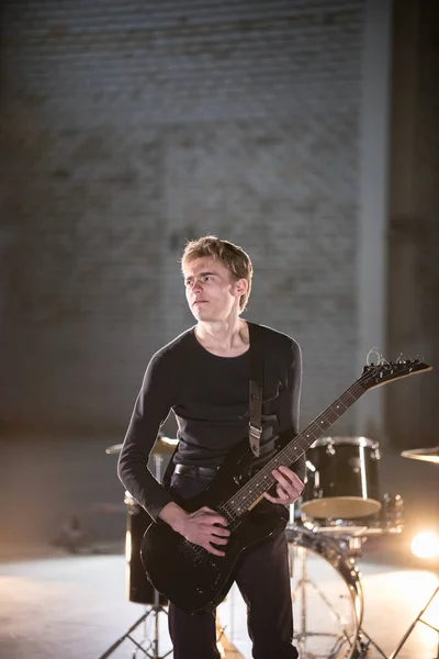 Un musicien jouant de la guitare dans un studio léger — Photo