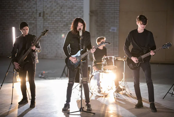 Un groupe de rock ayant une séance de répétition dans le grand hangar lumineux — Photo