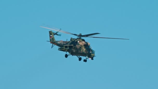 澄んだ空を飛ぶ軍緑色迷彩カラーリングヘリコプター — ストック動画