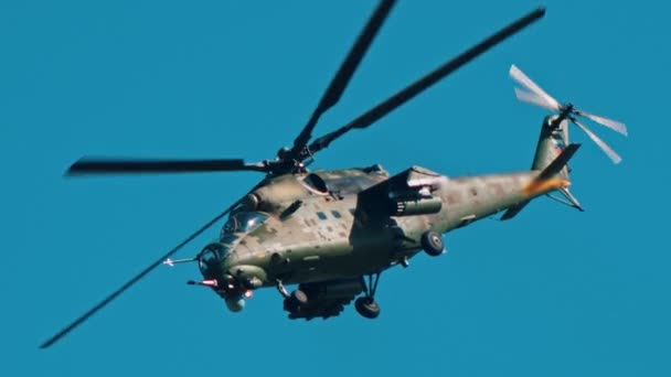 An combat green camouflage coloring helicopter flying in the blue sky — Stock Video
