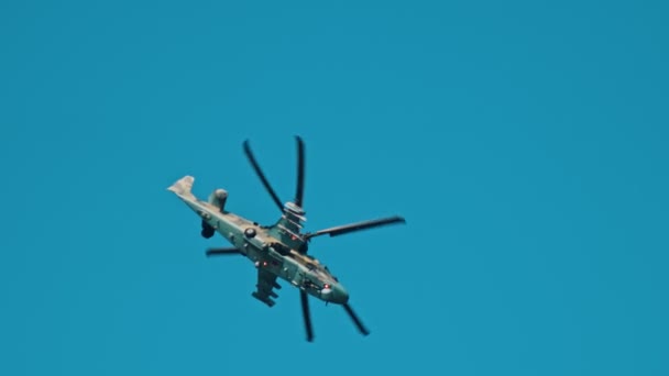 Ein Kampfhubschrauber mit grüner Tarnfärbung fliegt in den blauen Himmel — Stockvideo