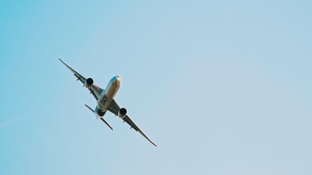 30 августа 2019 г. МОСКВА, РОССИЯ: Большой пассажирский самолет, летящий в небе - корпус, отражающий цвет золотого поля - AIRBUS A350 — стоковое видео