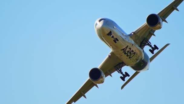 30 AGOSTO 2019 MOSCÚ, RUSIA: Un gran avión de pasajeros volando cerca del suelo - el cuerpo que refleja el color dorado del campo - puesta del sol temprana - vista inferior - AIRBUS A350 — Vídeos de Stock