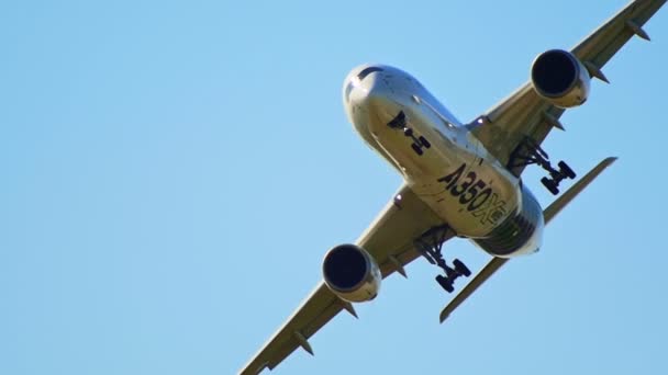 30 AGOSTO 2019 MOSCOW, RÚSSIA: Um grande avião de passageiros voando perto do solo - o corpus refletindo a cor do campo dourado - início do pôr-do-sol - vista de fundo - AIRBUS A350 — Vídeo de Stock