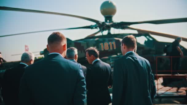30 AGOSTO 2019 MOSCÚ, RUSIA: una exposición aérea al aire libre - hombres de negocios en trajes de pie junto al helicóptero — Vídeos de Stock