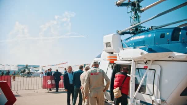 30 Agosto 2019 MOSCOW, RÚSSIA: Uma exposição de aeronaves ao ar livre - pessoas que estão perto da cabine de helicóptero militar - trabalhadores de controle também está ao seu lado — Vídeo de Stock