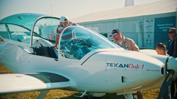 30 AGOSTO 2019 MOSCOW, RÚSSIA: Uma exposição de aeronaves ao ar livre - um hidroavião TEXANClub-1 - uma criança sentada na cabine piloto — Vídeo de Stock