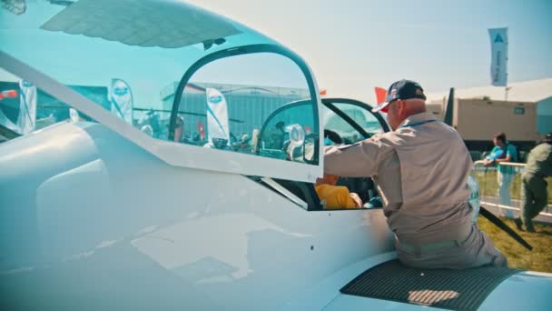 30 AGOSTO 2019 MOSCA, RUSSIA: Una mostra di velivoli all'aperto - un idrovolante TEXANClub-1 - un bambino seduto nella cabina pilota e un uomo si mette le cuffie in testa — Video Stock