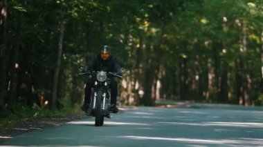 Ormanda motosiklete binen kasklı vahşi bir motosikletçi