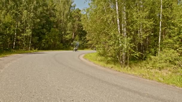 Dos hombres brutales motociclistas en casco montando una moto en el bosque - conduciendo a la vuelta de la esquina — Vídeo de stock