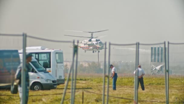 29 Αυγούστου 2019 Μόσχα, Ρωσία: ένα πυροσβεστικό ελικόπτερο εξαπλώνεται μια ροή νερού στο έδαφος που καίει καπνό — Αρχείο Βίντεο