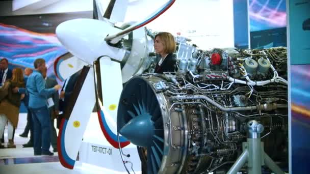 29 AOÛT 2019 MOSCOU, RUSSIE : échantillons de turbines d'avion exposées - une femme d'affaires qui regarde autour de soi — Video