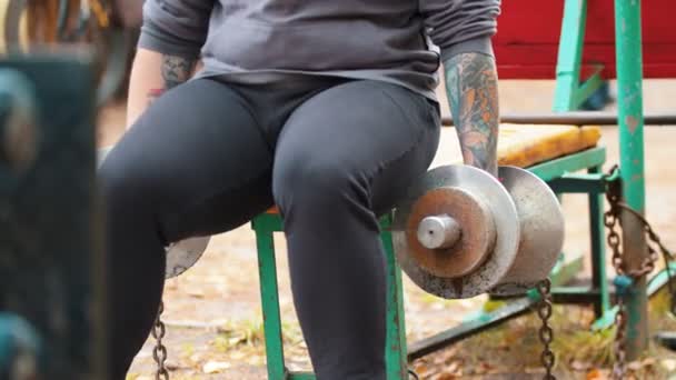 Bir adam vücut geliştirmeci halter çeker - açık spor zemin üzerinde eğitim — Stok video