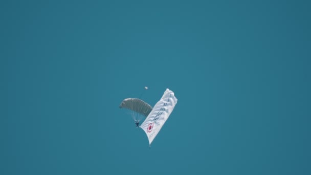 30 augusti 2019 Moskva, Ryssland: manar som flyger besegrar i skyen med öppnat, hoppa fallskärm och med sjunker med logoen av flygplan tillverkande företag — Stockvideo