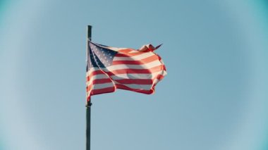 Berrak gökyüzünün arka planında rüzgarda esen Abd bayrağı