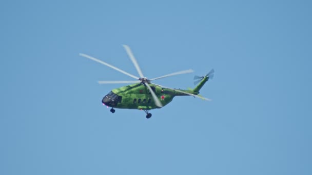 29 AGOSTO 2019 MOSCÚ, RUSIA: Un helicóptero militar de camuflaje verde brillante con estrellas rojas en el cuerpo volando en el cielo — Vídeo de stock