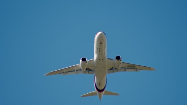 30. August 2019 Moskau, Russland: Ein großer weißer Passagier fliegt in den klaren blauen Himmel - suchoi superjet100 — Stockvideo