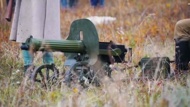 A military man in white coat standing by the machine gun — Stock Video