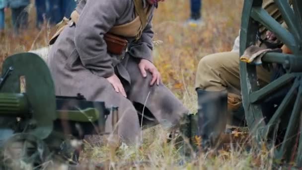 A military man in grey coat standing by the sitting near the soldier and talking with him — Stock Video