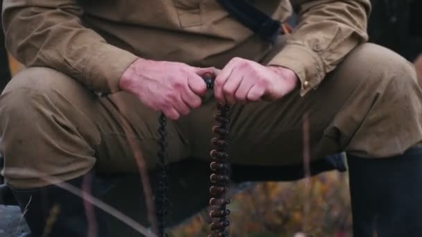 En man soldat förbereder ammunitionen för laddningen i kulsprutan — Stockvideo