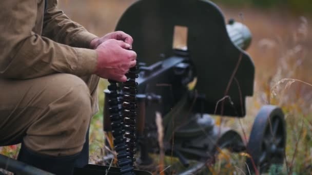 Un soldado hombre prepara la munición para la carga en la ametralladora - poner a los clientes en sus lugares — Vídeos de Stock