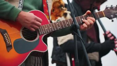 Festivalde sahnede enstrüman çalan bir müzik grubu. Tilki derisi giyen bir adam.